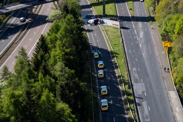 An HGV lorry is seen on its side after crashing through a barrier and falling from abridge on the M90 near Perth