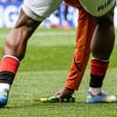 Rangers substitute Neraysho Kasanwirjo removes items from the pitch which were thrown by fans at Celtic's Viljami Sinisalo. (Photo by Alan Harvey / SNS Group)