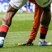 Rangers substitute Neraysho Kasanwirjo removes items from the pitch which were thrown by fans at Celtic's Viljami Sinisalo. (Photo by Alan Harvey / SNS Group)