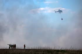 A helicopter tackles a wildfire near a wooded area in West Lothian in Fauldhouse. Picture: Jeff J Mitchell/Getty Images