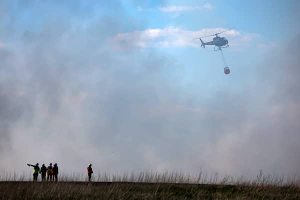 A helicopter tackles a wildfire near a wooded area in West Lothian in Fauldhouse. Picture: Jeff J Mitchell/Getty Images