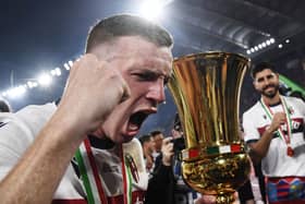 Bologna captain Lewis Ferguson holds the trophy after the 1-0 win over AC Milan in the Coppa Italia final.  (Photo by ISABELLA BONOTTO/AFP via Getty Images)          