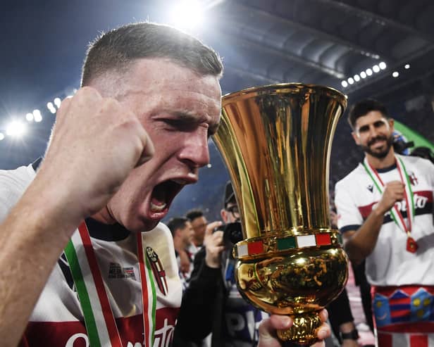 Bologna captain Lewis Ferguson holds the trophy after the 1-0 win over AC Milan in the Coppa Italia final.  (Photo by ISABELLA BONOTTO/AFP via Getty Images)          