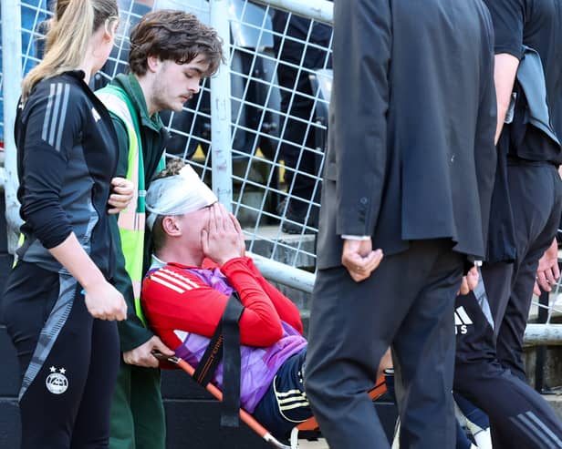 Aberdeen's Jack MacKenzie receives treatment after being hit with an object from the crowd at the end of the 2-1 defeat at Dundee United. (Photo by Roddy Scott / SNS Group)