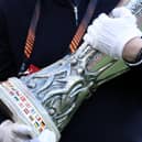 A UEFA official carrying the Europa Cup Trophy 
