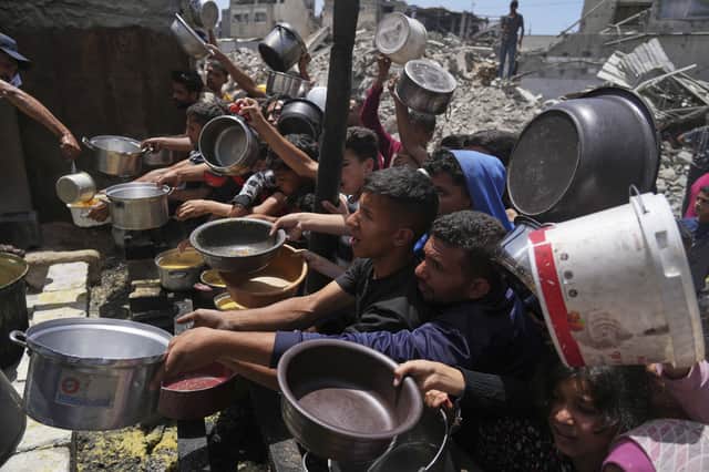 Palestinians struggle to get donated food at a community kitchen in Jabalia, in the northern Gaza Strip