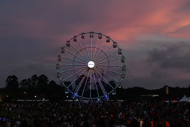 A 'Wheel of Fortune' mechanical attraction is seen during the sunset of the third day of the Lollapalooza music festival.
