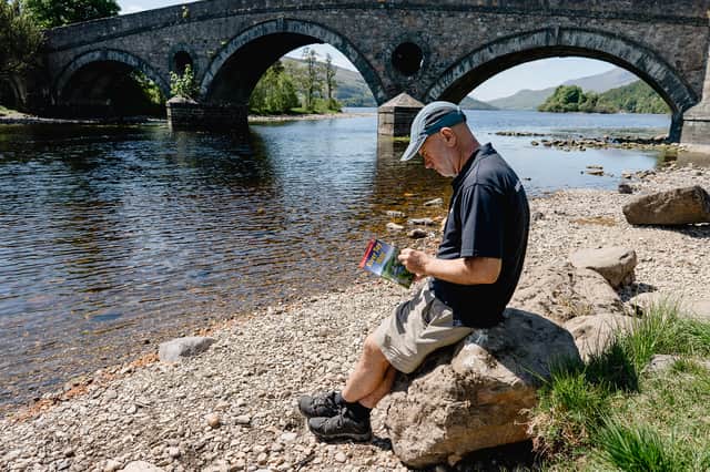 Perth and Kinross Countryside Trust strategic routes officer Andy Barrie reading the guide beside the Tay