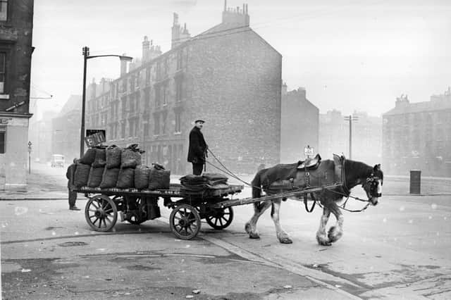 The coalman does his round by horse and cart in Glasgow around 1960 as modernity waits in the wings. PIC: Getty.