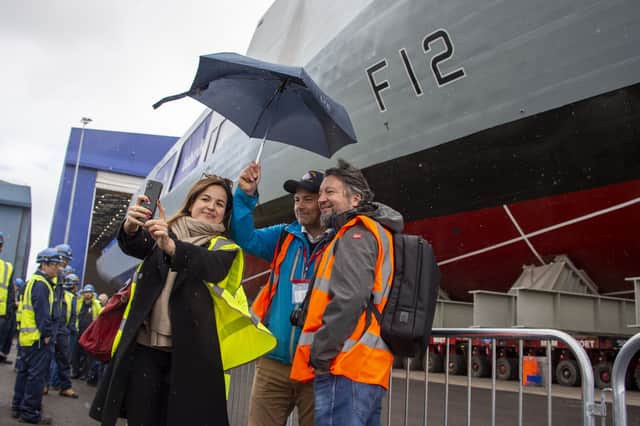 Workers watch in the Dock in Rosyth as HMS Venturer rolls out the build yard