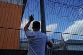 A protester communicates with people held inside the Brook House Immigration Removal Centre near Gatwick Airport (Picture:  Niklas Halle'n)