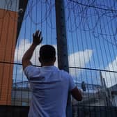 A protester communicates with people held inside the Brook House Immigration Removal Centre near Gatwick Airport (Picture:  Niklas Halle'n)