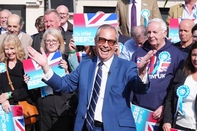 Reform UK leader Nigel Farage poses outside a pub in Morpeth, Northumberland, on the local election campaign trail in April