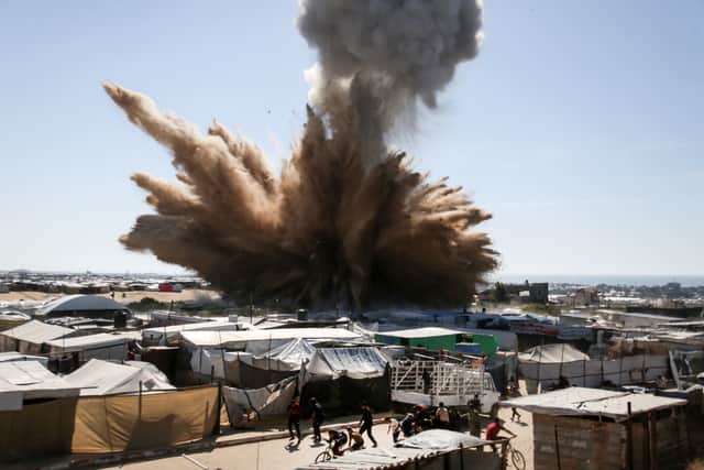 A plume of dust and smoke rises after an Israeli strike on a camp for displaced Palestinians in Khan Yunis in the southern Gaza Strip