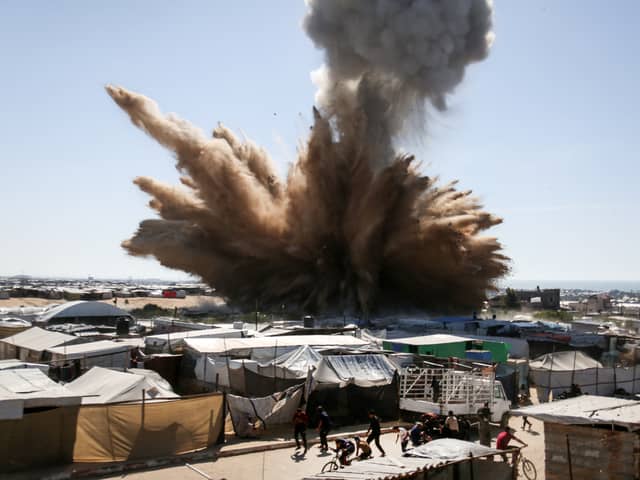 A plume of dust and smoke rises after an Israeli strike on a camp for displaced Palestinians in Khan Yunis in the southern Gaza Strip