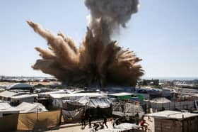 A plume of dust and smoke rises after an Israeli strike on a camp for displaced Palestinians in Khan Yunis in the southern Gaza Strip