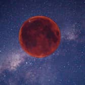 Digitally created image of a red Moon in the night sky.