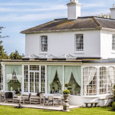 Merston House blends timeless Regency architecture with modern country living, complete with an orangery and sun-soaked patio for entertaining.