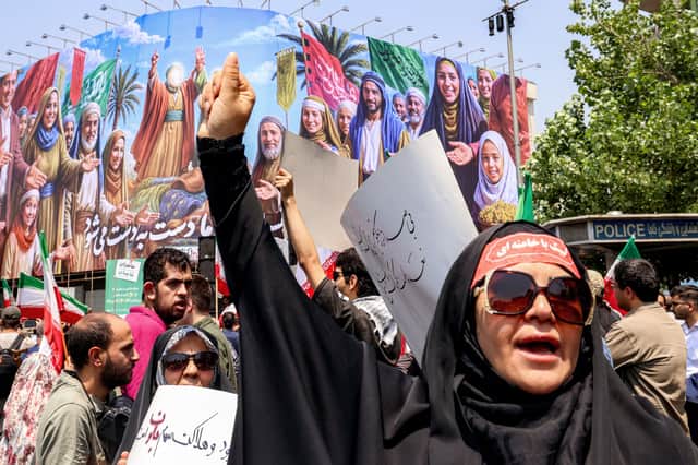 A woman chants slogans as people gather for a protest against Israel's wave of strikes on Iran in Enghelab (Revolution) Square in central Tehran