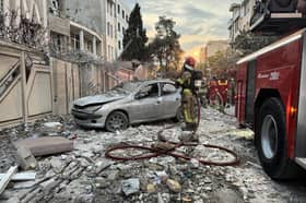 First-responders gather outside a building that was hit by an Israeli strike in Tehran on Friday
