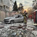First-responders gather outside a building that was hit by an Israeli strike in Tehran on Friday