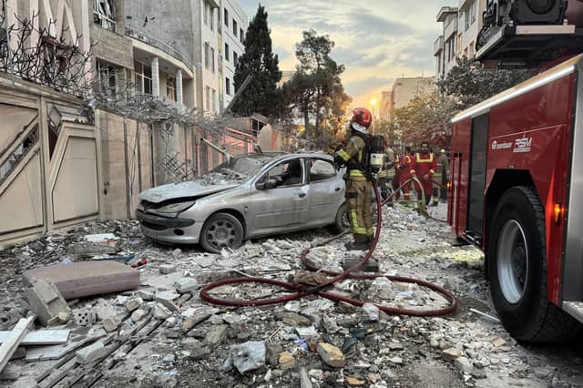 First-responders gather outside a building that was hit by an Israeli strike in Tehran on Friday