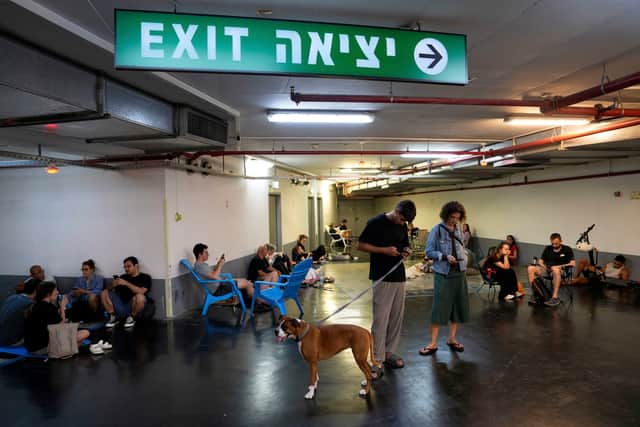 People take shelter during sirens warning of incoming fire in Tel Aviv. Picture: AP Photo/Baz Ratner