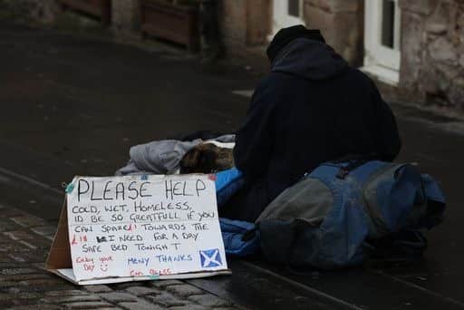 A homeless person and their dog on the Royal Mile in Edinburgh