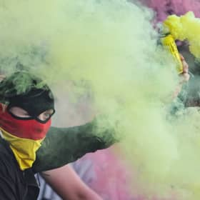 A Partick Thistle fan with a yellow flare during the Premiership Play-Off quarter-final second leg match against Ayr United at Somerset Park, on May 09, 2025. (Photo by Ross MacDonald / SNS Group)
