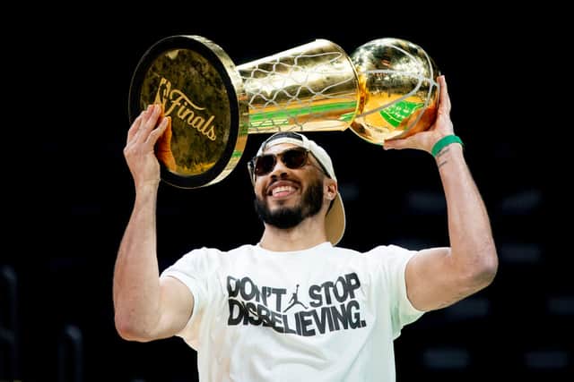 Jayson Tatum #0 of the Boston Celtics hoists the Larry O'Brien trophy after winning the NBA Championship in 2024.