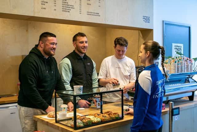 From left: Zander Fagerson, his brother Matt and Fraser Smith serve a customer at the Zone.One cafe,  located inside the Saints Sport, at the University of St Andrews.