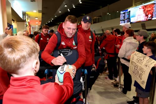 British and Irish Lions fly-half Finn Russell signs autographs for a fan upon arrival at Perth International Airport on June 22, 2025, ahead of the team's rugby match against Western Force.