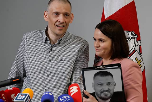 Exiled Belarusian opposition leader Sviatlana Tikhanovskaya (R) and her husband Siarhei Tikhanovsky, Belarusian opposition activist released from a Belarusian prison, with a photograph on Mr Tikhanovsky before he was imprisoned.