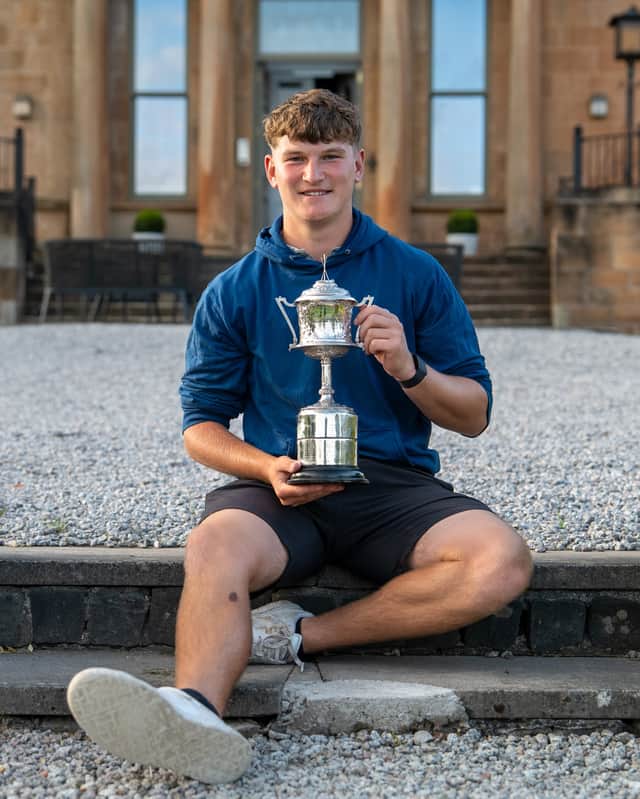Will Coxon, a student at the University of Stirling, shows off the Tennant Cup at Glasgow Golf Club