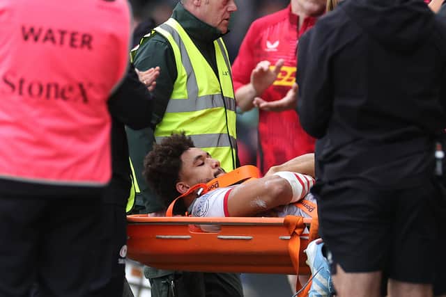 Andy Onyeama-Christie of Saracens is carried off after being injured during the Gallagher Premiership Rugby match between Harlequins and Saracens at the Stoop on October 13, 2024.