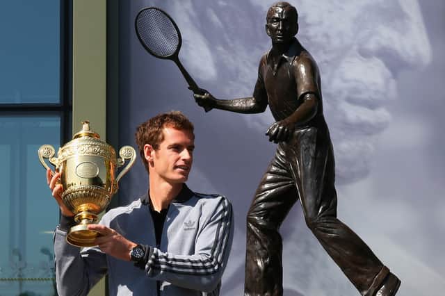 Andy Murray's poses with his first Wimbledon singles trophy in front of the statue of Fred Perry (Picture: Julian Finney)