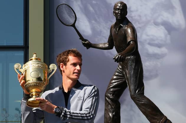 Andy Murray's poses with his first Wimbledon singles trophy in front of the statue of Fred Perry (Picture: Julian Finney)