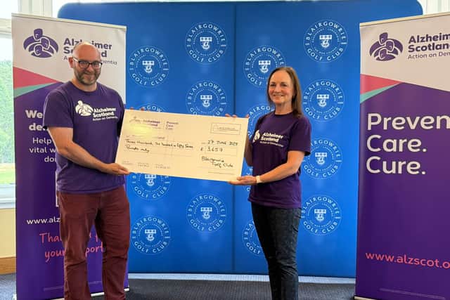 Margaret Marshall presents her cheque to Alzheimer Scotland’s Lindsay Beveridge from the proceeds raised from her golf marathon