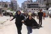 Two girls react after an Israeli strike in Gaza on Tuesday