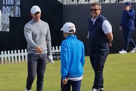 Rory McIlroy greets 12-year-old Andrew Shaw before walking up the sixth hole with him during the Genesis Scottish Open Pro-Am