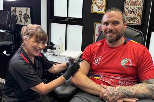 Lorraine Kelly 'tattooing' Island Games shot put competitor and tattoo artist Calum Elder