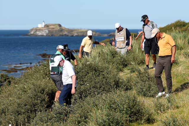 Bob MacIntyre searches for his ball along with playing partners Scottie Scheffler and Adam Scott on the 13th hole at The Renaissance Club