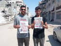 Two men in Gaza hold photographs of two-year-old Omer Siman Tov and nine-month-old Kfir Bibas, who both died as a result of the October 7 attack on Israeli by Hamas