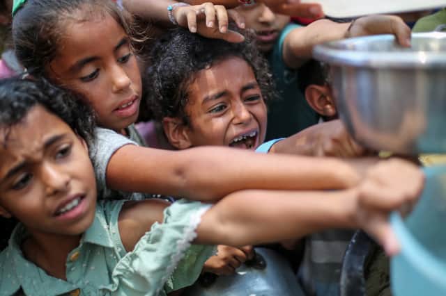 Palestinian children line up to receive a hot meal at a food distribution point in Nuseirat in the Gaza Strip on June 30 (Picture: Eyad Baba)