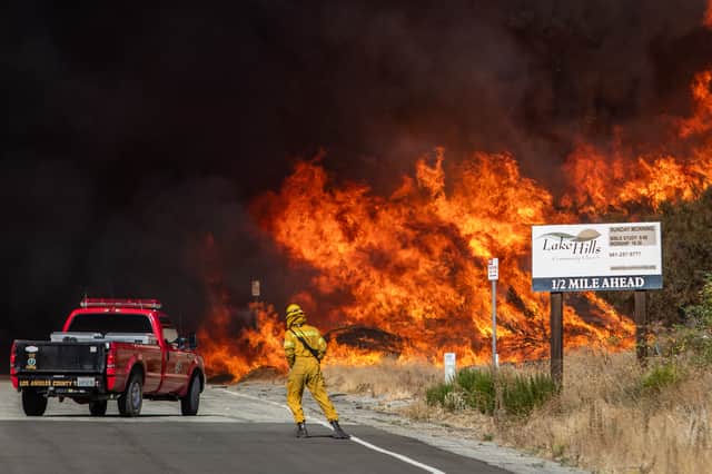 Firefighters retreat as an unseasonal wildfire rages in northwest Los Angeles county in January (Picture: Apu Gomes)