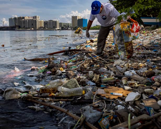 A volunteer collects plastic waste washed up on the shores of Freedom Island in Manila Bay, Philippines (Picture: Ezra Acayan)