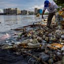A volunteer collects plastic waste washed up on the shores of Freedom Island in Manila Bay, Philippines (Picture: Ezra Acayan)
