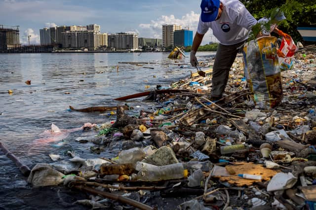 A volunteer collects plastic waste washed up on the shores of Freedom Island in Manila Bay, Philippines (Picture: Ezra Acayan)
