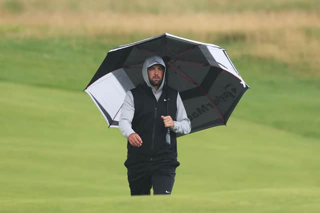 World No 1 Scottie Scheffler shelters under his umbrella during day two of The 153rd Open Championship at Royal Portrush