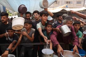 Children queue for food distributed by a charity kitchen at the Nuseirat refugee camp in the central Gaza Strip earlier this month (Picture: Eyad Baba)